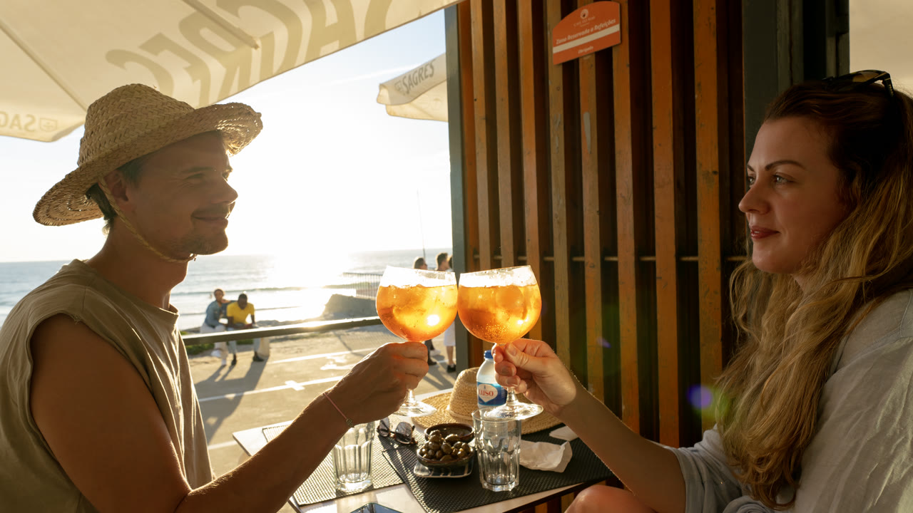 Esplanada do Café do Mar ao fim da tarde, mesas postas com vista para o mar